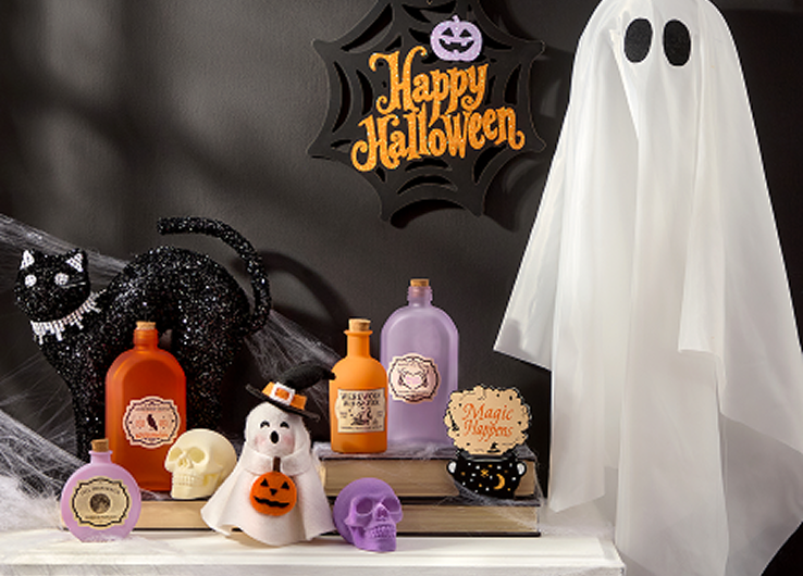 Happy Halloween decor with ghost figure, black cat, skull accents and seasonal decorations