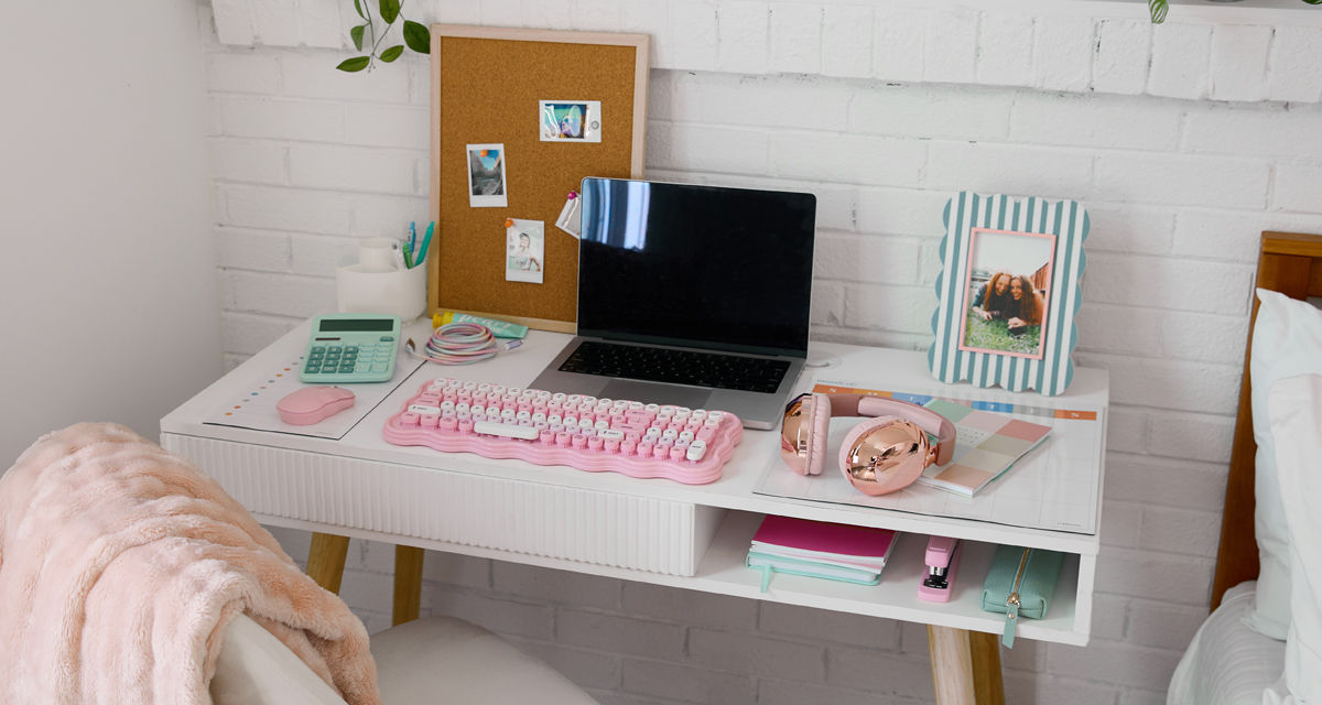 Study desk with pastel desk accessories: pink keyboard and mouse, mint calculator, journals, headphones & more from pOpshelf.