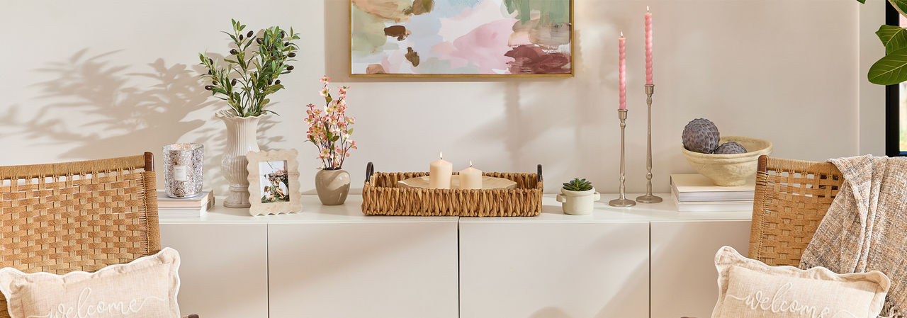 Home Shores decor collection for spring: driftwood decor, coastal pillows, beachy wall art, rattan mirror, floral, candleholders & more.