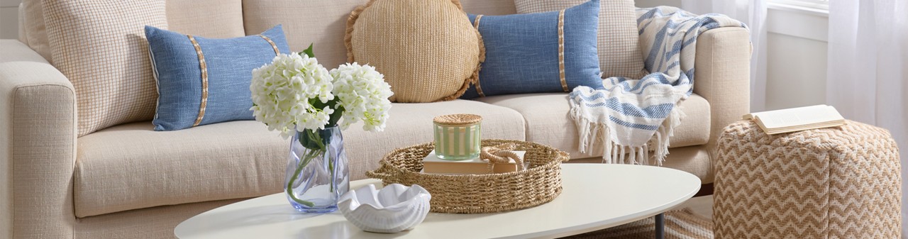Home Shores decor collection for spring: driftwood decor, coastal pillows, beachy wall art, rattan mirror, floral, candleholders & more.
