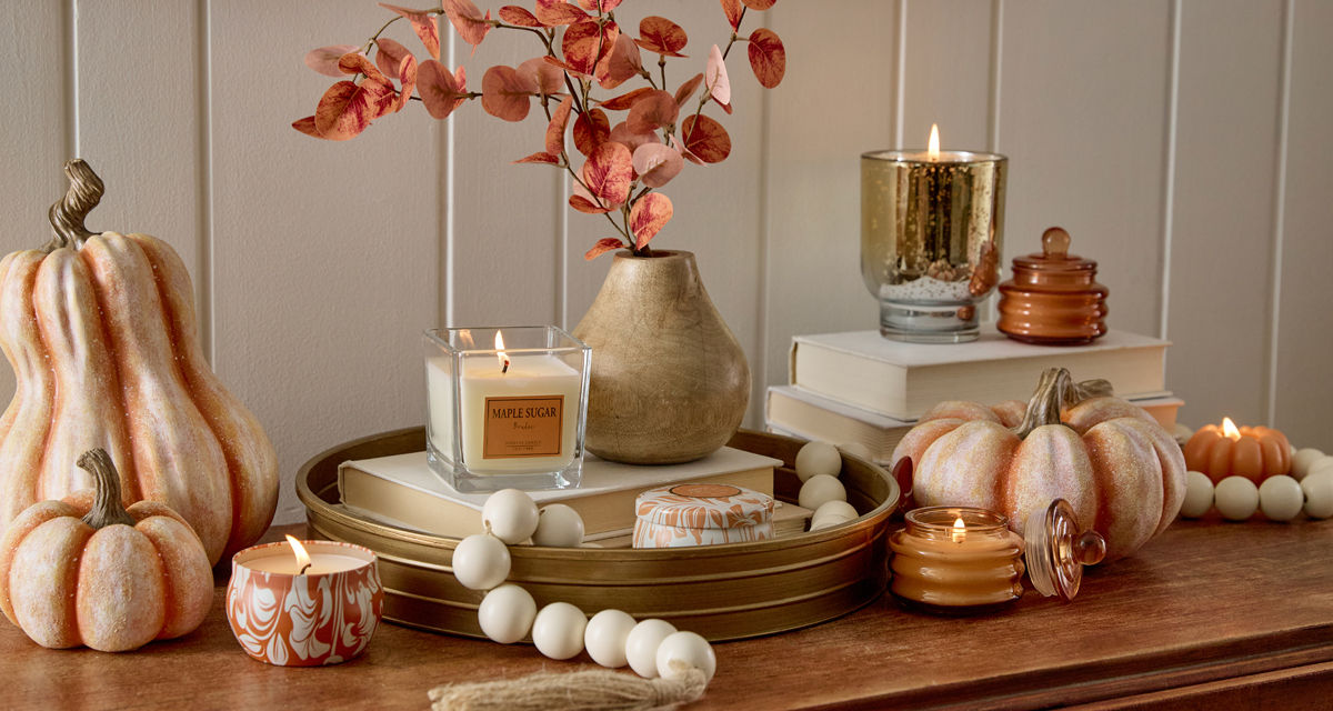 Various fall jar candles and pumpkin-shaped candles in fall scents.