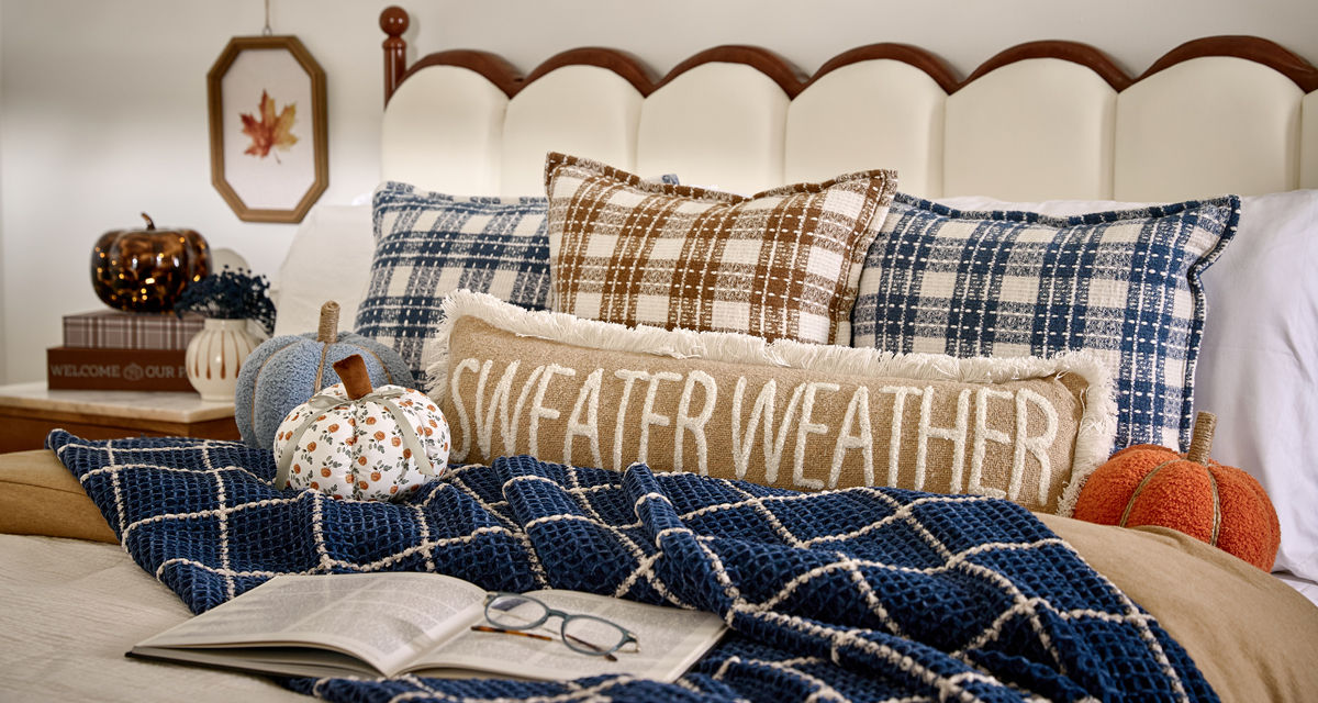 Bedroom decorated for fall with pumpkin decor, fall floral, fall pillows and throws & more.