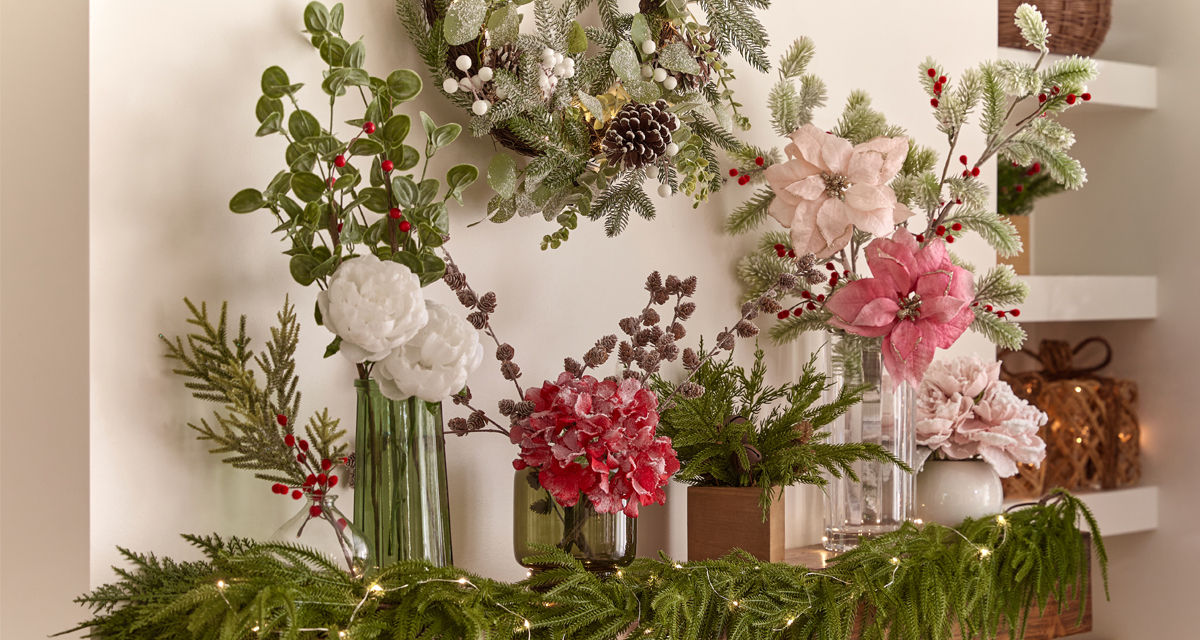 Vases filled with faux Christmas florals and greenery: red, pink & white poinsettias, frosted & flocked pine and pinecones, Christmas wreath, holly and berries, and more.