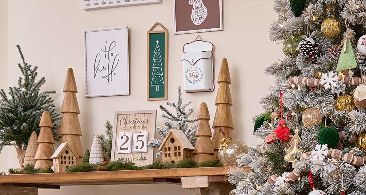 Room with Christmas tree decorated for Christmas in the Winter Woodlands colletion with large solid-wood trees and nutcrackers, wooden garland, wooden village houses, and rustic and deer accents.