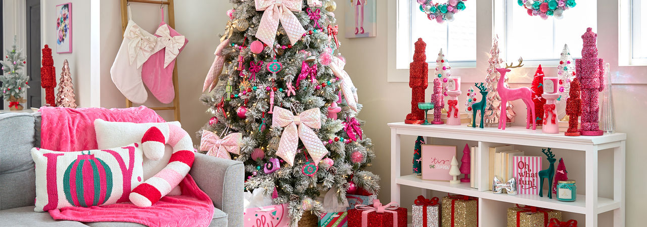 Room decorated with the Merry Merry pink, bows, and sparkly decor collection from pOpshelf: tree ornments, wall art, pillows, throws, tinsel nutcrackers, bottlebrush trees, candles, ornament wreaths & garland.