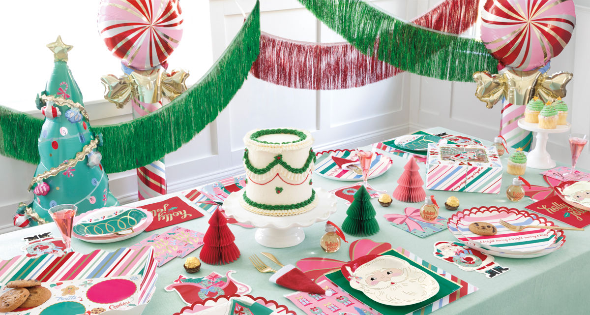 Christmas party table with festive pastel Santa and stripes-themed party plates and napkins, honeycomb tree centerpiece, and more.