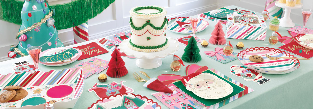 Christmas party table with festive pastel Santa and stripes-themed party plates and napkins, honeycomb tree centerpiece, and more.