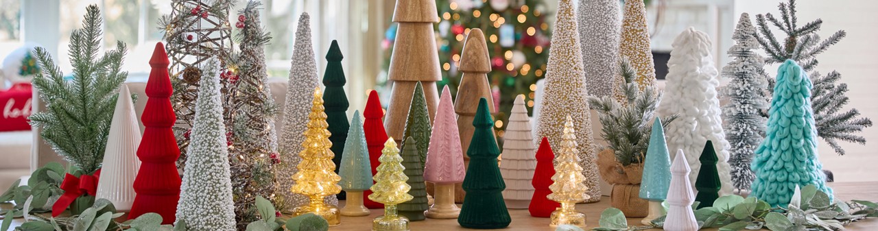 Christmas tree tabletop decor in an array of styles, colors, and materials such as wood, ceramic, felt, and more.