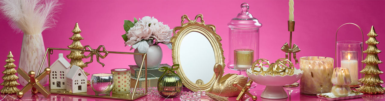 Gift ideas for the decorator from pOpshelf: gold bow candleholders, candles, glass and gold lantern, gold bow mirror, tabletop decor & more.