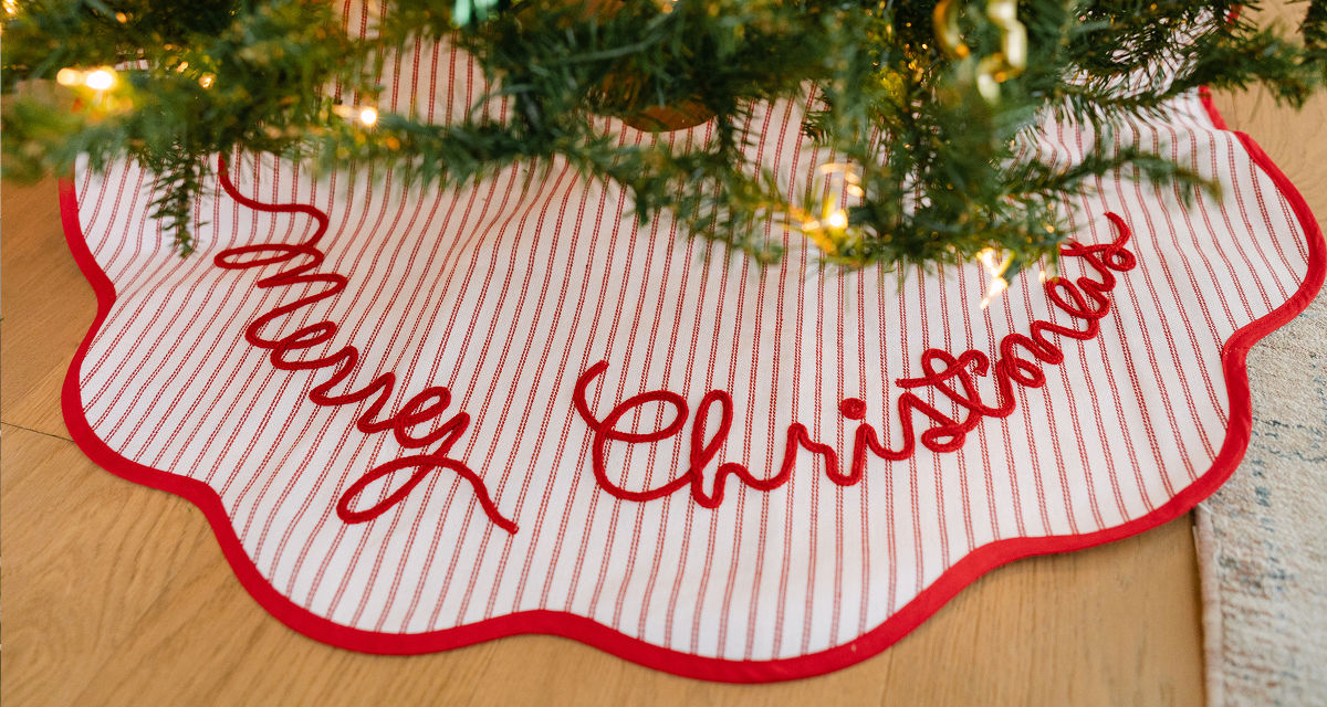 Red & white striped "Merry Christmas" tree skirt around a decorated Christmas tree.