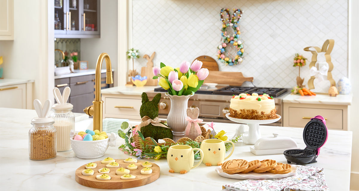 Easter kitchen with wooden egg serving board, bunny canisters, bunny charcuterie board, bunny waffle maker, and Easter decor.