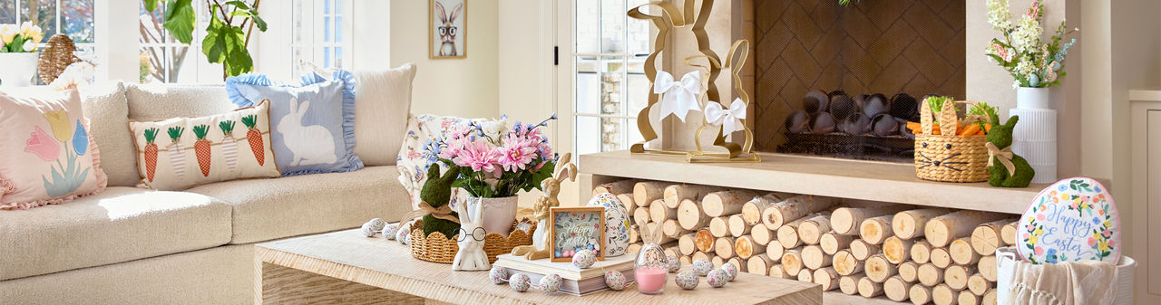 Living room decorated with Easter decor from pOpshelf: metal and rattan bunnies, framed bunny art, egg garland, pillows, bunny & carrot decor, and more.