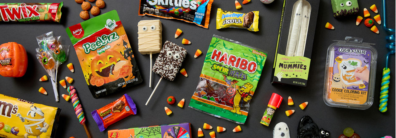 Various colorful Halloween candy and treats: Peelerz, gummy candy, decorated cookie and rice krispy treat pops, Reese's Pumpkins, candy corn & more.