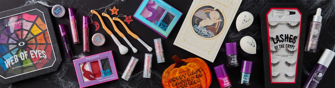 Halloween-themed makeup, nail art, makeup brushes, and false eyelashes on a black background.