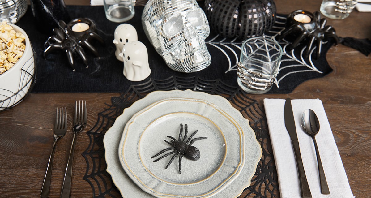 Halloween dining essentials: spider web placemats and table runner, ghost sale & pepper shakers, web serving bowl & more.