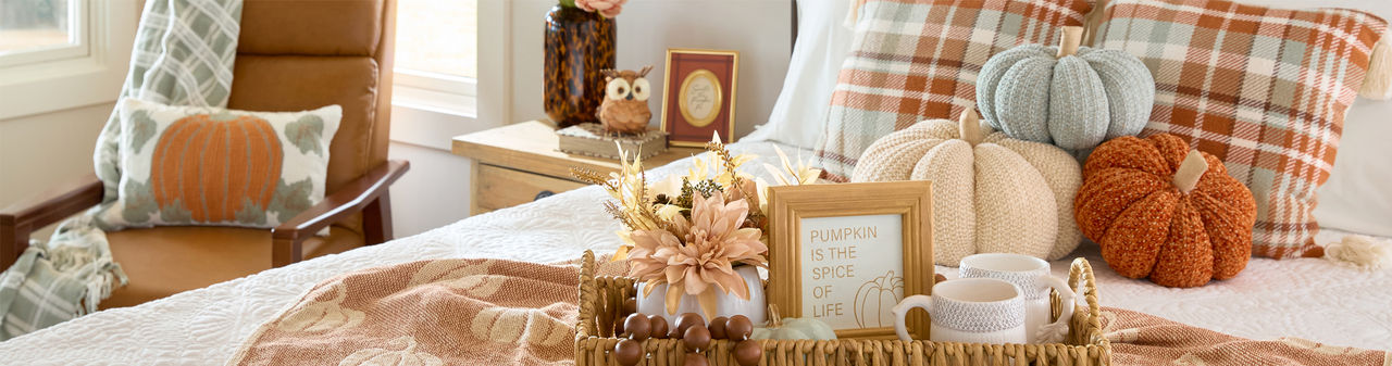 Bedroom decorated for fall with pumpkin decor, fall floral, fall pillows and throws & more.
