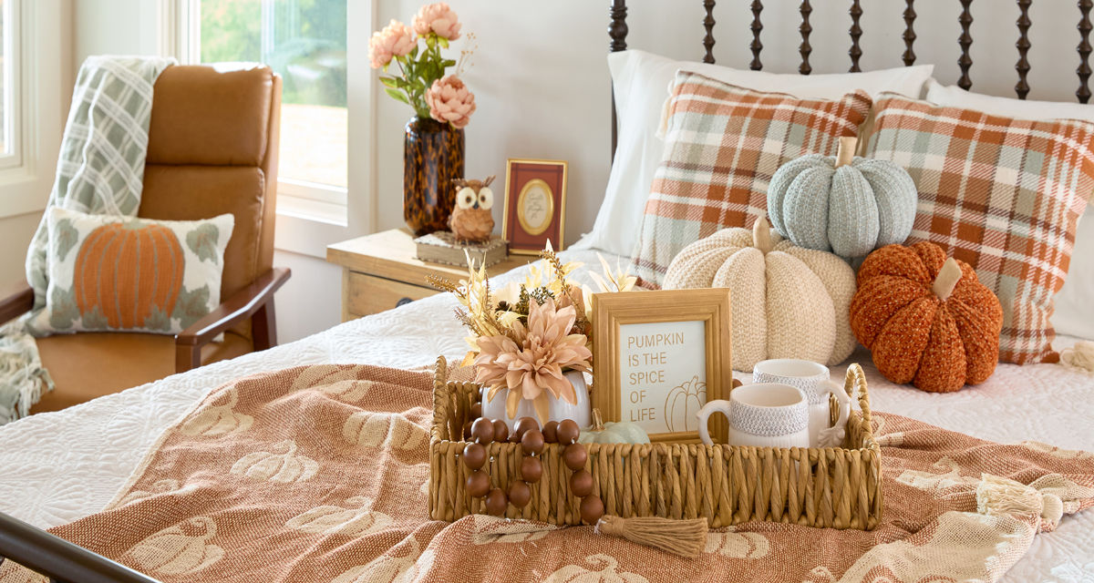Bedroom decorated for fall with pumpkin decor, fall floral, fall pillows and throws & more.
