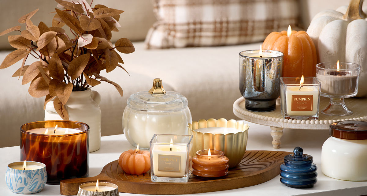 Various fall jar candles and pumpkin-shaped candles in fall scents.