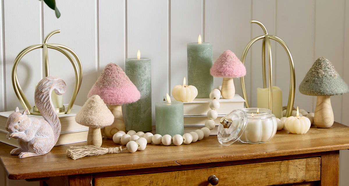 Fall whimsical woodlands tabletop decor on entryway table: mushrooms, LED pillar candles, metal pumpkins, candles & more.