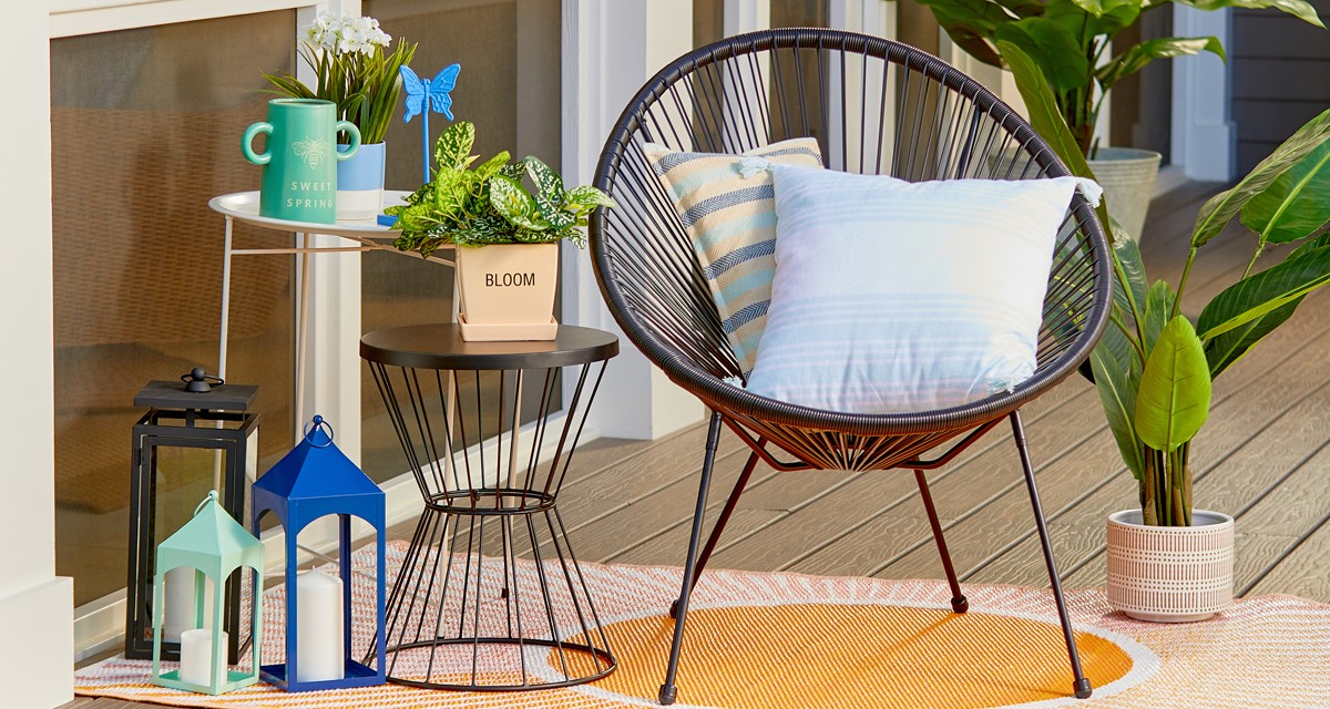 Lawn & garden patio with table, chair with pillows, plant stands, lanterns, and outdoor decor from pOpshelf.