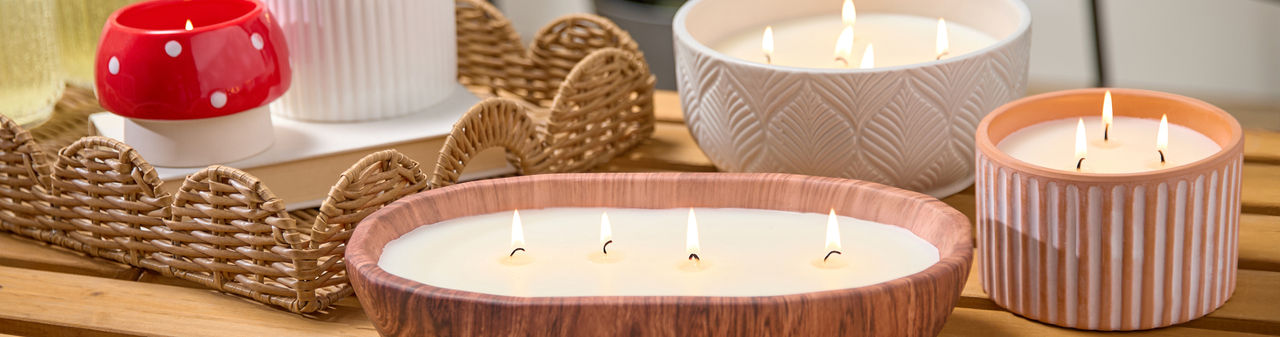 Citronella candles from pOpshelf in various sizes and designs on a wooden table.
