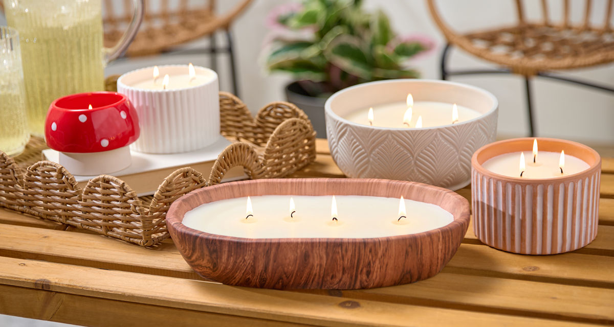 Citronella candles from pOpshelf in various sizes and designs on a wooden table.