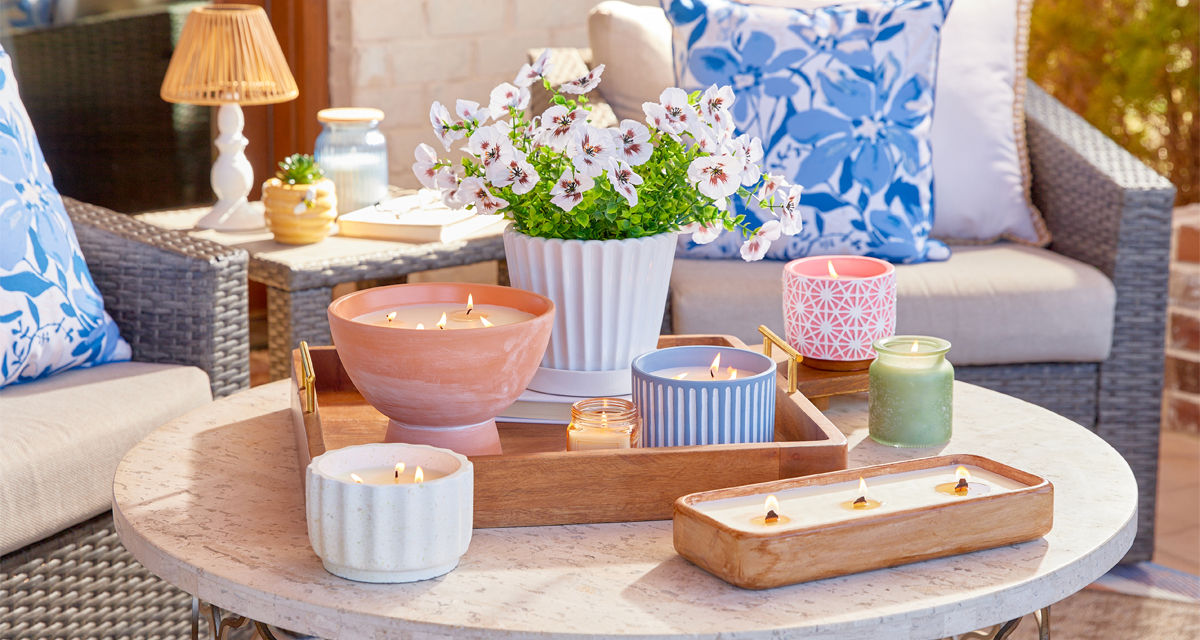 Citronella candles from pOpshelf in various sizes and designs on a wooden table.