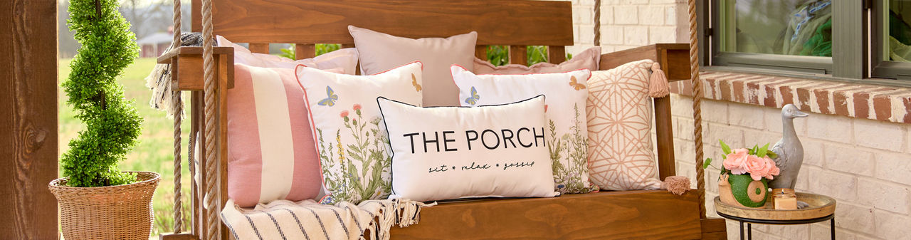 Porch swing with multiple outdoor pillows in various sizes, colors, and designs from pOpshelf.