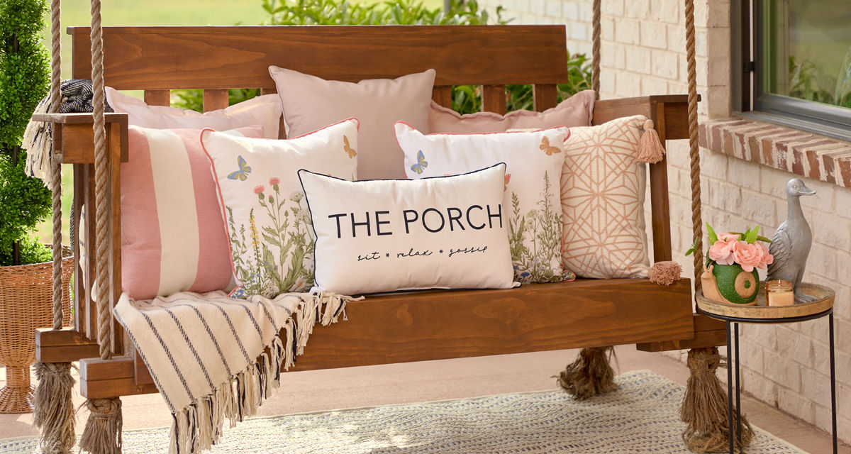 Porch swing with multiple outdoor pillows in various sizes, colors, and designs from pOpshelf.
