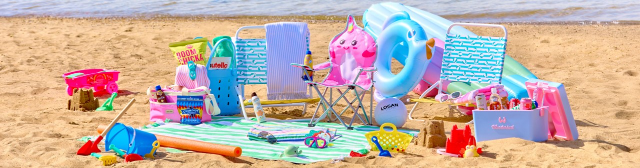 Beach scene with folding beach chairs, beach umbrella, beach towels, insulated coolers, snacks & sand toys.