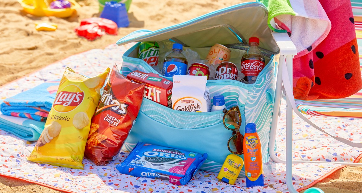 Blue Wave soft-side insulated cooler with drink and snacks on the beach with beach chairs, umbrellas, beach towels & more.