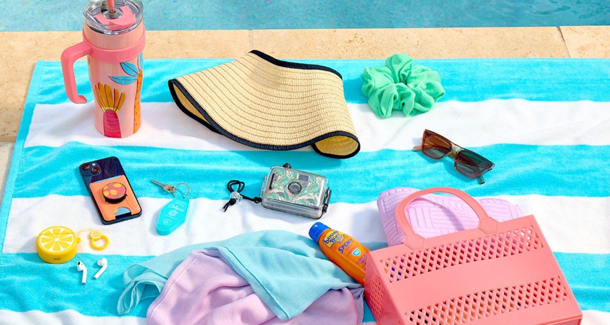 Striped beach towel poolside with sun visor, pool cover up, sunglasses, scrunchie, jelly beach tote & more.