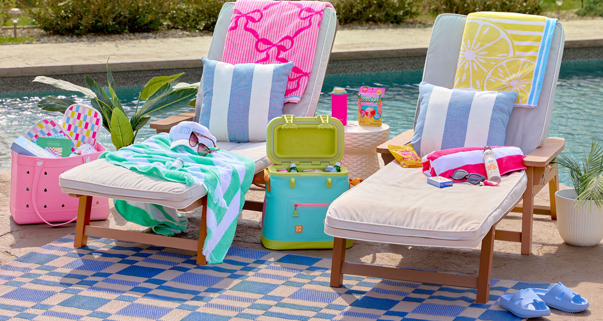 Yellow & green folding beach chairs poolside with floats, sand & water toys, beach towels, cooler with drinks & more.