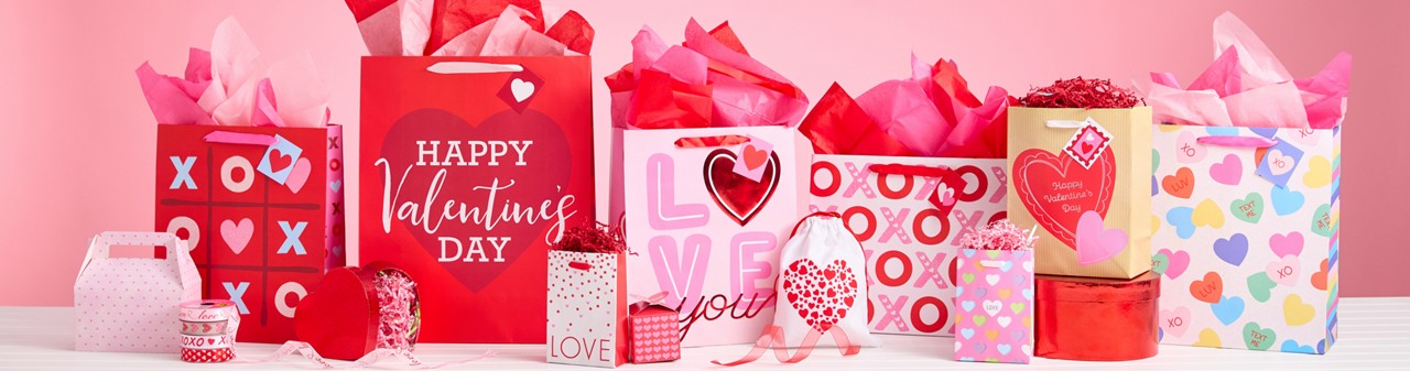 Various Valentine's Day gift bags, pink and red tissue paper, valentine's day boxes, and valentine's bows and ribbon from pOpshelf. 
