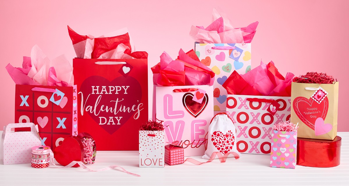 Various Valentine's Day gift bags, pink and red tissue paper, valentine's day boxes, and valentine's bows and ribbon from pOpshelf. 