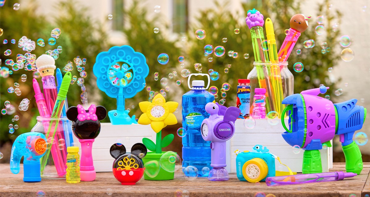 Outdoor table with bubbles, bubble blowers, bubble wands, and bubble machines in various colors and designs.