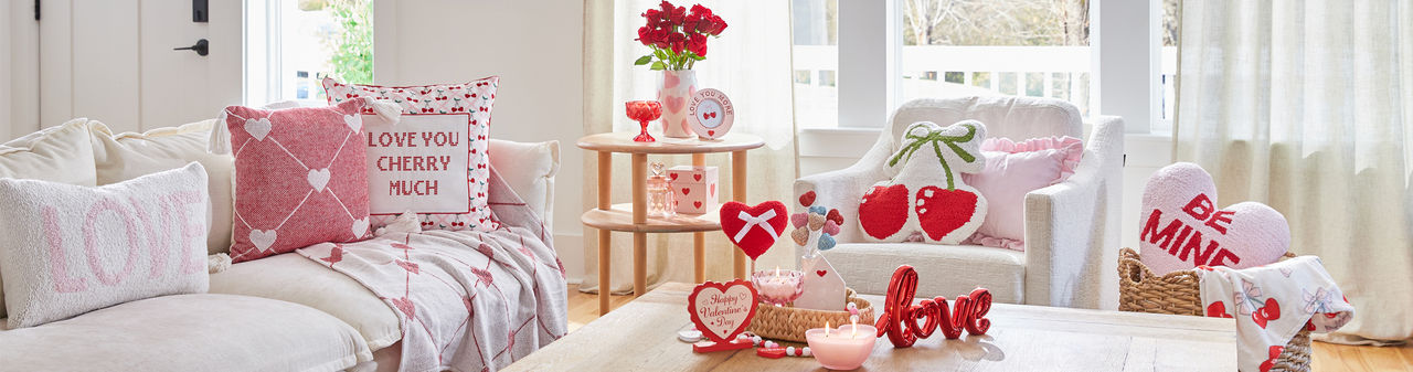 Living room decorated with pOpshelf Valentine's Day home decor pieces: heart pilows, floral wall art, Valentine's candles, and valentine's day decor items.