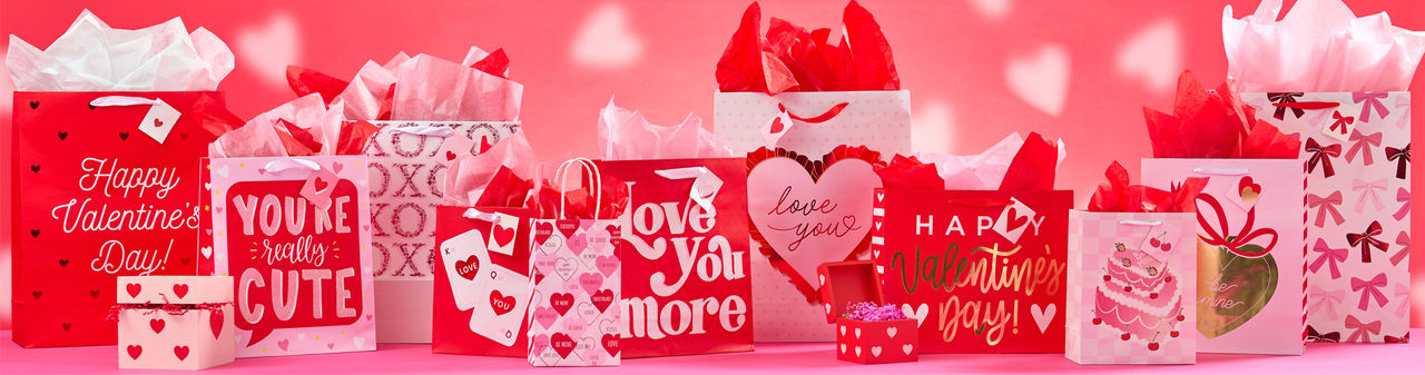 Various Valentine's Day gift bags, pink and red tissue paper, valentine's day boxes, and valentine's bows and ribbon from pOpshelf. 