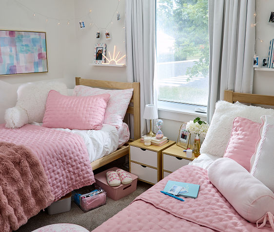 Dorm room decorated with pink bedding and dorm decor from pOpshelf.