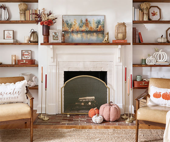 A neutral-toned living room is decorated with classic fall decor from pOpshelf in shades of orange and cream with plaid patterns, pumpkin accents, and autumn scented candles.