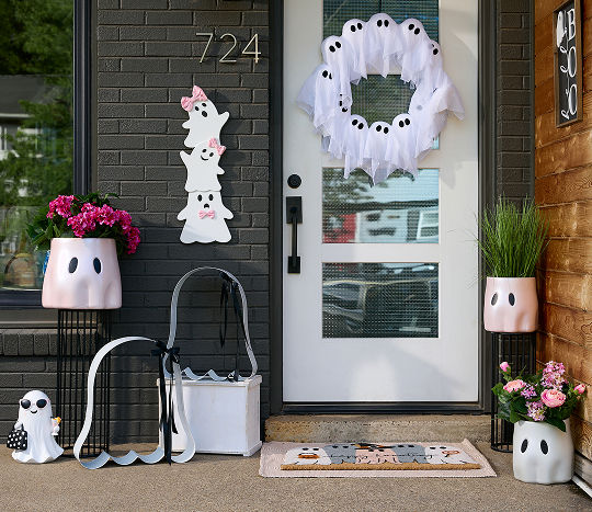 Front porch decor from pOpshelf displayed on a summer Halloween themed front porch featuring ghost decorations in a pink and white color palette.