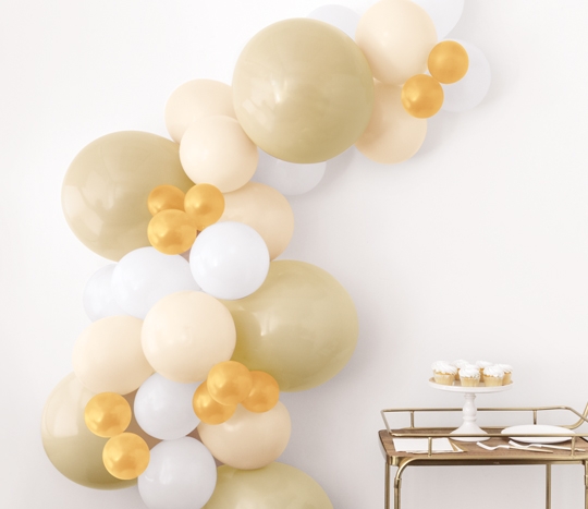 White, champagne colored latex balloon kit displayed at a dinosaur-themed party.