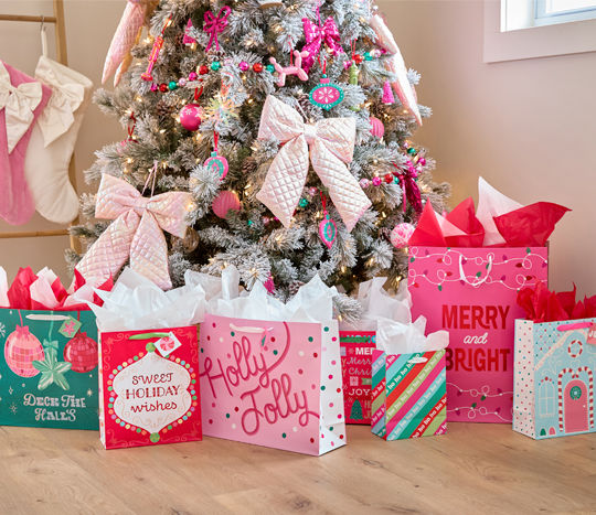 various gift bags around Christmas tree 