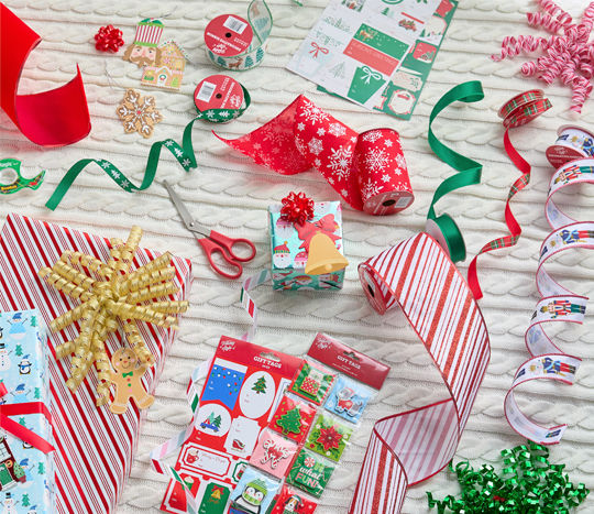 tags, ribbons and bows laid out to wrap a Christmas gift