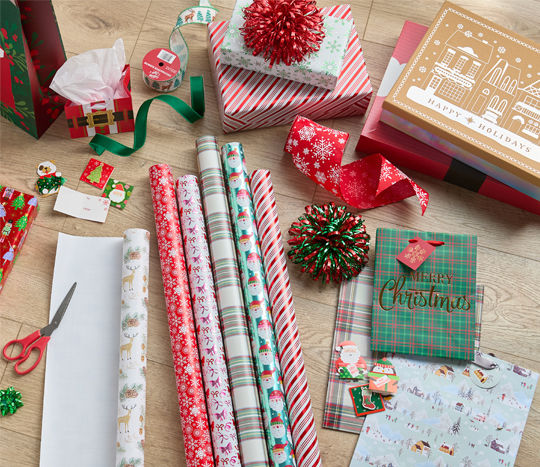 wrapping paper, ribbons and bows laid out to wrap a gift