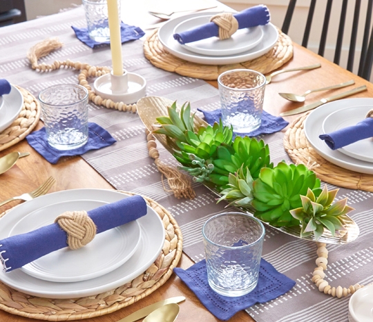 Table set with gray striped table runner, blue linen napkins and coasters, and other table serveware from pOpshelf.