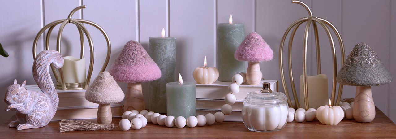 Fall whimsical woodlands tabletop decor on entryway table: mushrooms, LED pillar candles, metal pumpkins, candles & more.