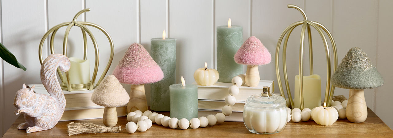 Fall whimsical woodlands tabletop decor on entryway table: mushrooms, LED pillar candles, metal pumpkins, candles & more.