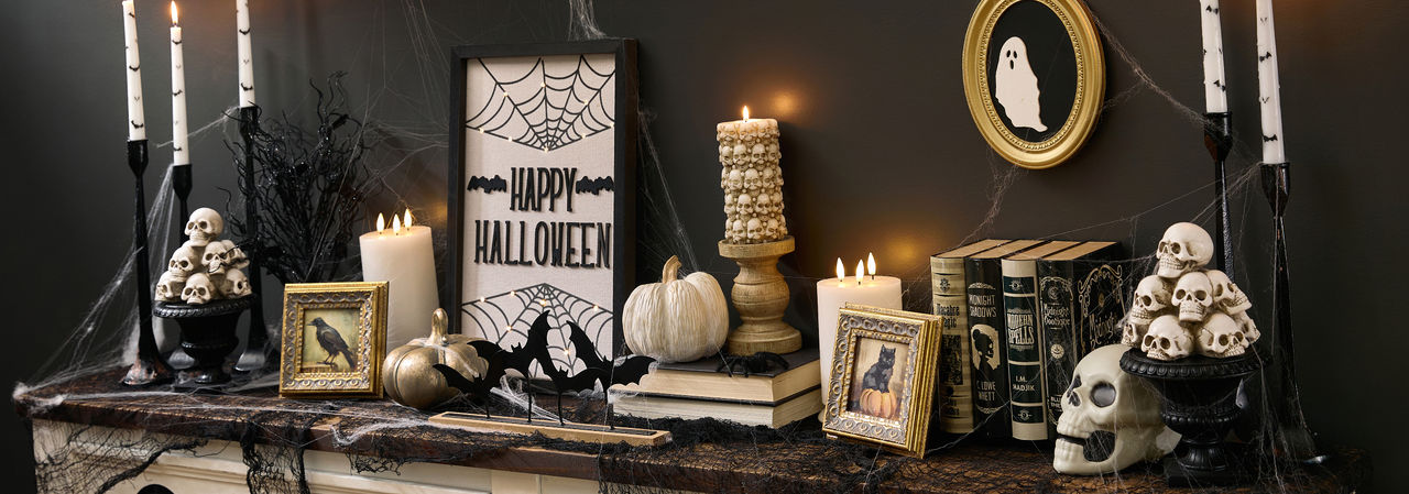Sppoky Halloween foyer decorated with black and gold decor, creepy candles, and eerie wall hangings.
